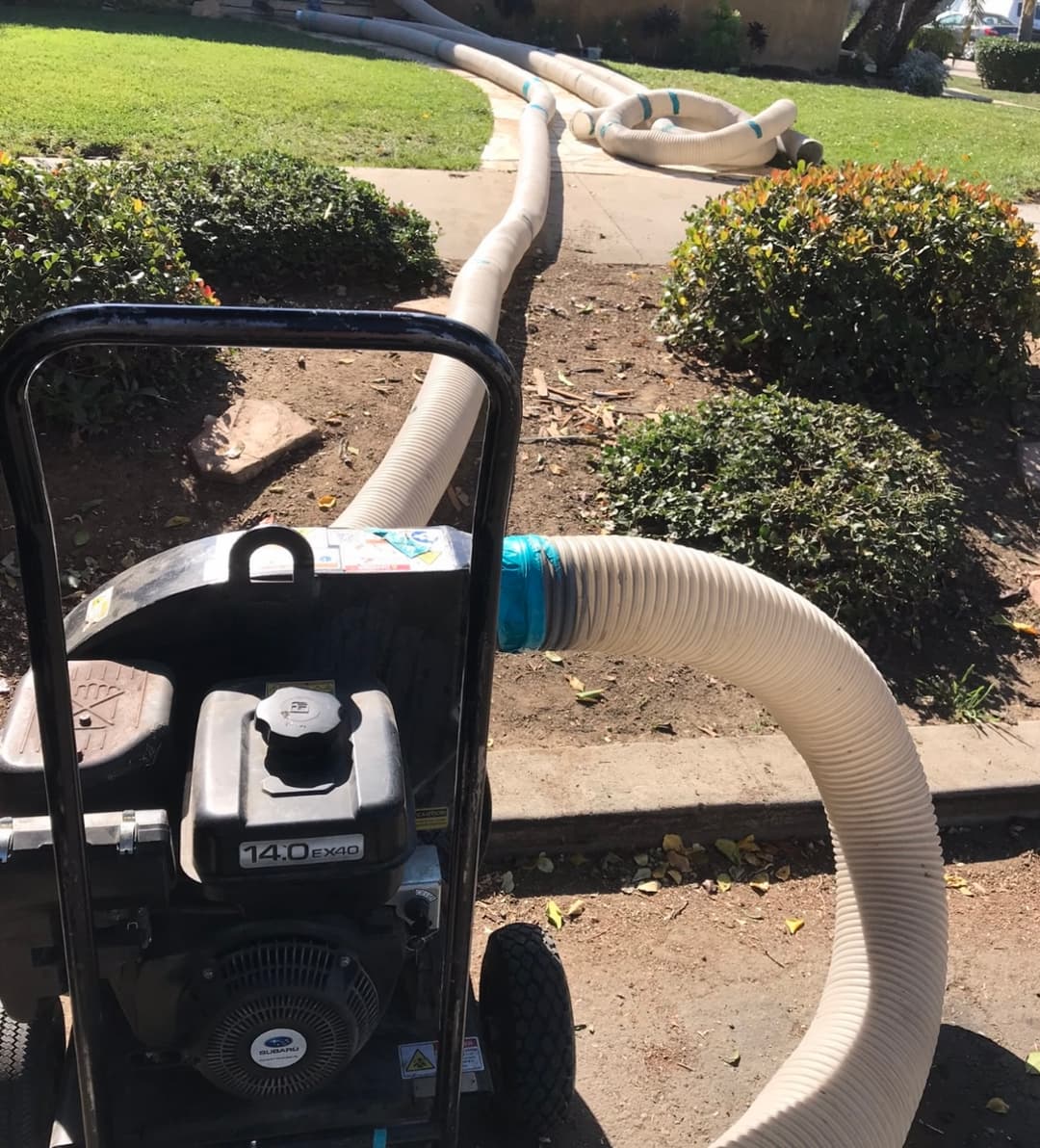 Machine blowing insulation from the street into a home