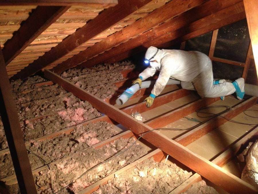 Man putting insulation into an attic in a home